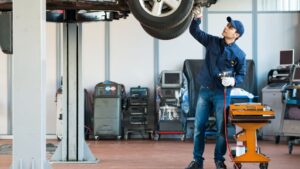 technician inspecting vehicle on car lift